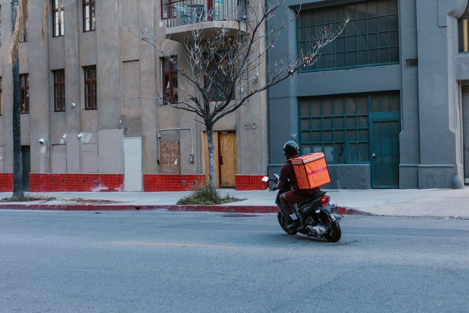 A Stallionex rider on a delivery scooter navigating a city street